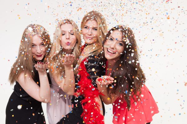 Junge Frauen feiern ausgelassen vor Fotobox