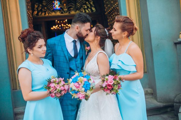 bride and groom newlyweds with happy groomsmans and bridesmaids posing at church after luxury wedding ceremony